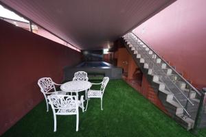a balcony with a table and chairs and a staircase at Saj Earth Resort , Cochin Airport in Nedumbassery