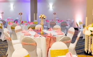 a banquet hall with tables and chairs with pink and yellow napkins at Wyndham Garden Madison Fitchburg in Madison +59 photos