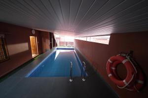 a swimming pool with a red life preserver in a building at Saj Earth Resort , Cochin Airport in Nedumbassery