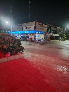 an empty parking lot in front of a store at night at INTOWN Hotel in Islamabad