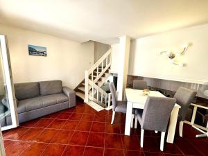 a living room with a couch and a table and chairs at Casa do Mar & Sesimbra Center View in Sesimbra