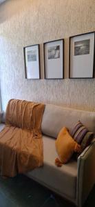 a couch in a room with four pictures on the wall at micro 3 in Volta Redonda