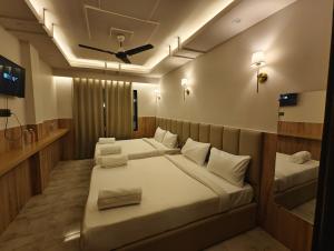 a bedroom with two beds and a ceiling fan at Hotel hk haridwar By hk guest house in Haridwār