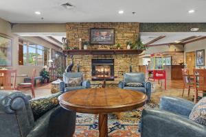 a living room with a fireplace and a table and chairs at The Inn On The River in Pigeon Forge