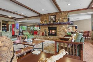 a living room with a stone fireplace and tables at The Inn On The River in Pigeon Forge