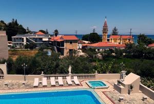 a swimming pool with chairs and a building at Abela Family Hotel in Argassi +6 photos