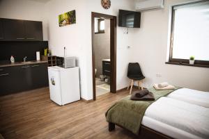 a bedroom with a bed and a small refrigerator at Öreg Fűz Apartman in Mosonmagyaróvár