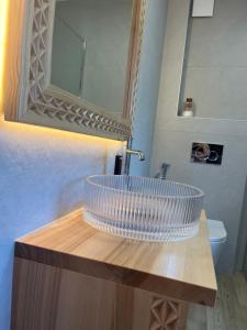 a bathroom sink with a glass bowl on a wooden counter at Gościniec u Bobaków in Ząb