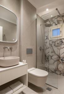 a bathroom with a sink and a toilet and a shower at AMARÉ suites in Nikiti +68 photos