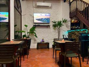 a restaurant with tables and chairs and a flat screen tv at Hotel Los Pinos in Colonia del Sacramento +24 photos