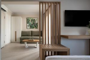 a living room with a couch and a tv at AMARÉ suites in Nikiti