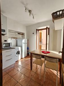 a kitchen with a table and a kitchen with a refrigerator at Casa dello sciatore in Limone Piemonte