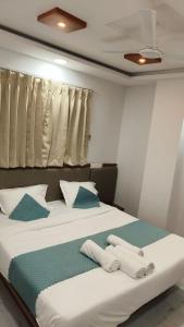 a bedroom with a bed with towels on it at Hotel shree lodging in Jogeshwāri
