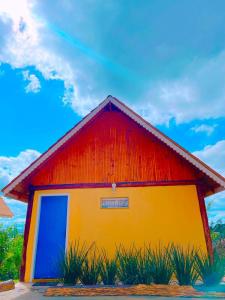 a red and yellow building with a sky in the background at Sítio Emanoel Bangalôs in Domingos Martins