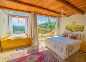 a bedroom with a bed and a large window at Sítio Emanoel Bangalôs in Domingos Martins