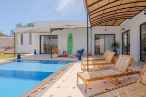 a villa with a swimming pool and two chairs at 3Moon Guesthouse in Aït Yassine