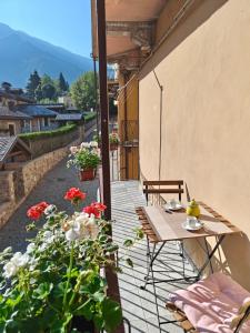 a balcony with a table and flowers on a building at Casa dello sciatore in Limone Piemonte