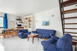a living room with blue couches and a table at Casa Violina - Portoferraio in Portoferraio