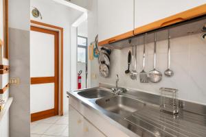 a kitchen with a stainless steel sink and utensils at Casa Violina - Portoferraio in Portoferraio +19 photos