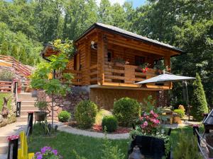 a wooden cabin with a table and an umbrella at Etnokutak Milojevic in Paraćin