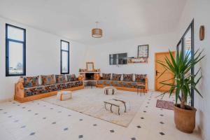 a large living room with couches and a potted plant at 3Moon Guesthouse in Aït Yassine