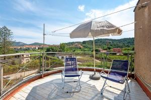 two chairs and an umbrella on a balcony at Casa Violina - Portoferraio in Portoferraio