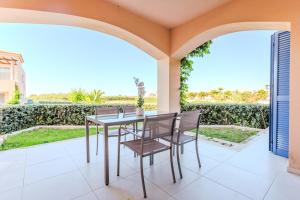 a dining room with a table and chairs on a patio at Resitour - Aphrodite Beachfront in Pírgos Psilonérou
