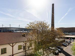 a building with a chimney and a building with a tree at ibis Saint-Denis Stade Ouest in Saint-Denis