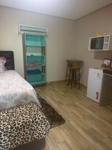 a bedroom with a bed and a kitchen with a table at Residencial Beatriz centro in Formosa +7 photos