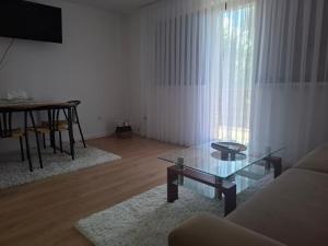 a living room with a table and a glass coffee table at Holiday house Šadrvan Sarajevo in Hadžići