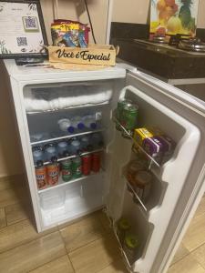 an open refrigerator filled with drinks and sodas at Residencial Beatriz centro in Formosa