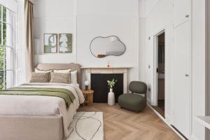 a bedroom with a bed and a chair at GuestReady - The Crescent in London