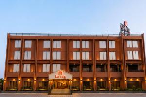 a large building with a hotel sign in front of it at Lords Inn Sanand in Chharodi