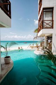 a swimming pool with a view of the ocean at ZAN Tropical Beach Adults Only in Dimbuni