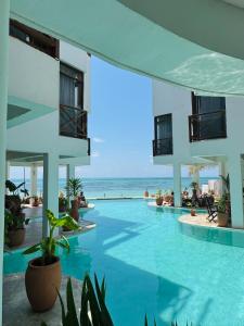 a swimming pool with the ocean in the background at ZAN Tropical Beach Adults Only in Dimbuni