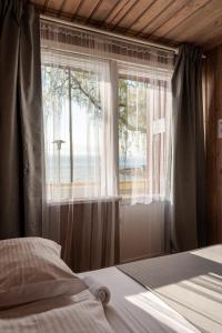 a bedroom with a window with a view of the ocean at Poilsio namai El Nido in Nida