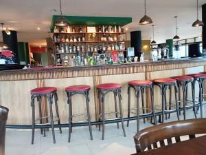 a row of red stools at a bar at Torre Melos, 2do piso, centro, con cochera in Villa Carlos Paz