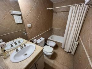 a bathroom with a sink and a toilet and a tub at Torre Melos, 2do piso, centro, con cochera in Villa Carlos Paz