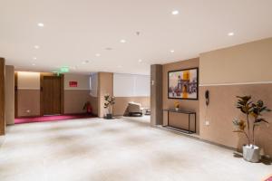 a large lobby with a waiting area with a waiting room at Lords Inn Sanand in Chharodi +69 photos