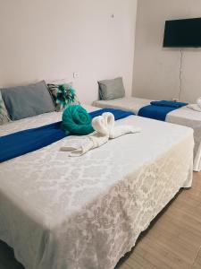 two beds with towels on top of them in a room at Bom Viver Pousada ltda in Viçosa do Ceará