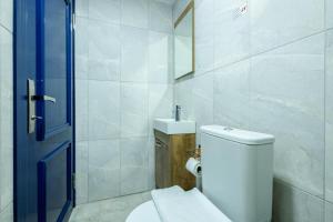 a white bathroom with a toilet and a sink at Selanikli Hotel Heybeliada in Istanbul