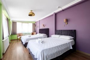 two beds in a room with purple and green walls at Selanikli Hotel Heybeliada in Istanbul +14 photos