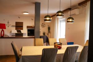 a dining room with tables and chairs and lights at Paola Apartment in Pula