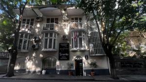a white building with balconies on a street at Boutique Hotel Iveria in Tbilisi City