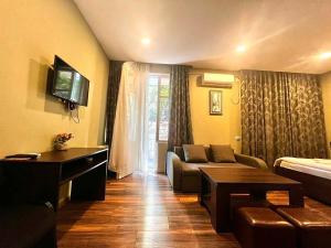 a living room with a couch and a tv at Boutique Hotel Iveria in Tbilisi City +42 photos