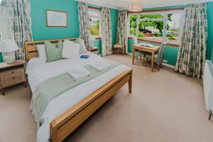 a bedroom with a large bed and a table at The Otter Lodge in Broadford