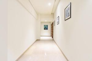 an empty hallway with white walls and white tile floors at FabHotel City Point Executive in Pune