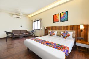 a hotel room with a large bed in a room at FabHotel City Point Executive in Pune +26 photos