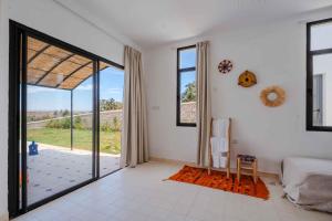 a bedroom with a bed and a large glass door at 3Moon Guesthouse in Aït Yassine