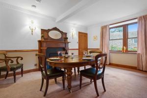 a dining room with a table and a fireplace at Keepers Cottage in Dunkeld +19 photos